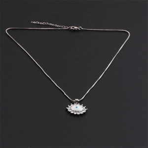Detailed macro view of silver evil eye pendant with sparkling white cubic zirconia stones