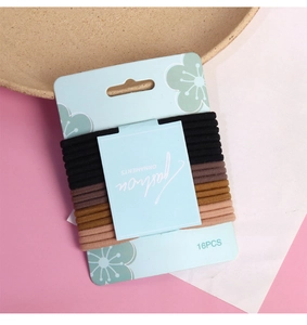 Set of 16 high-elastic basic hair ties in neutral gradient colors on floral card display
