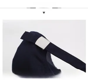 Detailed view of the adjustable metal buckle and navy twill strap on the baseball cap
