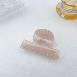 Detailed shot of handmade marble acetate hair claw clip in soft pink translucent finish