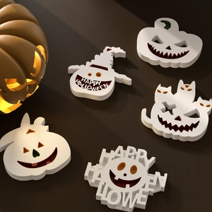Detailed view of 5-piece white Halloween pumpkin and ghost resin molds on dark background