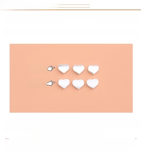 Macro view of S925 sterling silver heart beads showing smooth and brushed metal textures