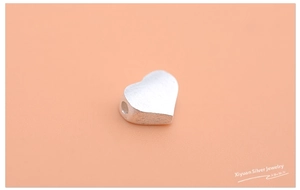 Close-up of S925 sterling silver heart bead with brushed texture for DIY jewelry making