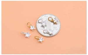 Macro view of tiny 925 silver star pendants with sparkling cubic zirconia in gold and silver