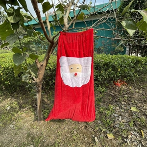 Thick red velvet Christmas drawstring gift bag with Santa Claus pattern hanging on tree