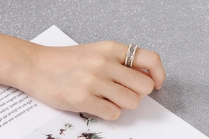 Close-up of rose gold stainless steel multi-layered ring with crystals on finger