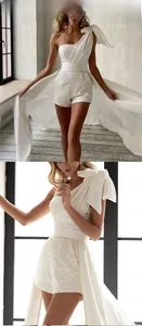 Detail eines weißen Paillettenkleides mit Satin-Schleife und eleganter langer Schleppe