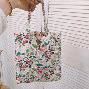Détail d'un sac cabas en toile à fleurs avec bouton pression en laiton doré