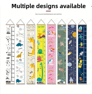 Detail view of Scandinavian style height chart with wooden hangers and dinosaur patterns