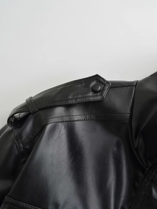 Close-up of black faux leather bomber jacket shoulder epaulets and stitching details