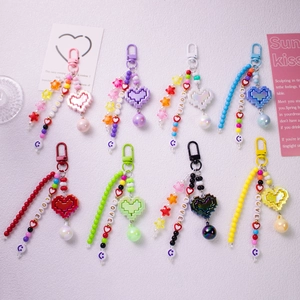 Detailed close-up of colorful pixel heart keychains with LOVE letter beads and stars