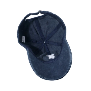 Internal details of cotton baseball cap showing stitching, metal buckle, and wash label