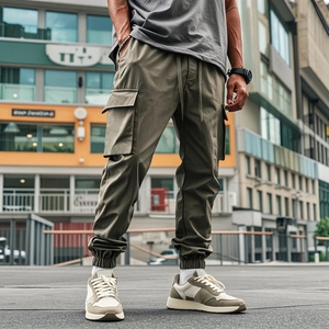 Detail of olive cargo pants featuring large side pockets and joggers elastic cuffs
