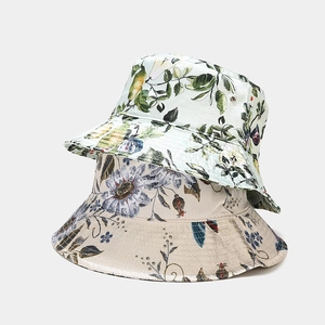 Dettaglio di cappelli da sole in cotone con stampe floreali di margherite e motivi di pere