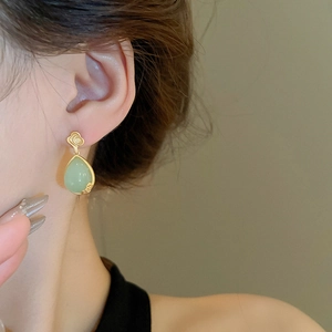 Detail of flower cloud resin waterdrop earrings in light green and gold on model