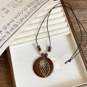 Macro view of bohemian wooden beads and hollow metal leaf pendant necklace