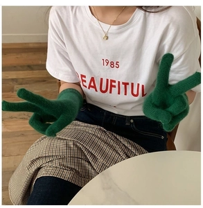Close-up of green knitted thermal gloves paired with white casual 1985 BEAUTIFUL t-shirt