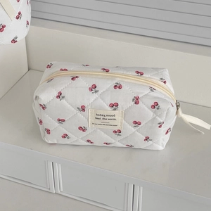 Quilted cherry print makeup bag in cream white with minimalist rectangular cloth label