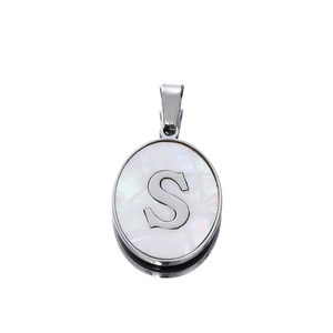 Detailed close-up of oval silver pendant with white mother of pearl and metal letter S