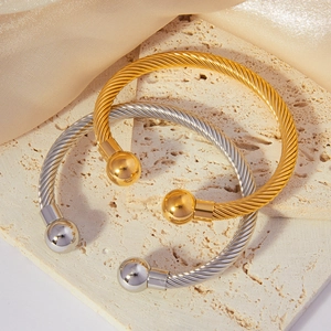 Elegant twisted cable open cuff bracelet in gold and silver finish with metal ball ends