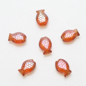 Macro detail of six reddish-brown fish-shaped glass beads for DIY jewelry making