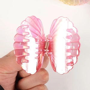 Pink translucent shell hair claw clip with colorful iridescent finish on white background
