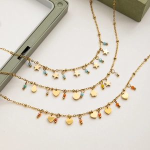Close-up of 18K gold stainless steel chains with orange crystal hearts and star charms