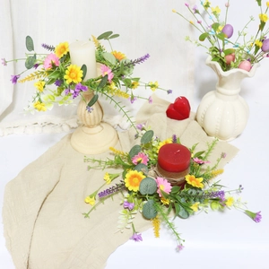 Detail of yellow and pink daisy candle ring with lush greenery for table decoration
