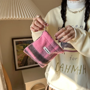 Close-up of pink and brown plaid wool drawstring pouch with branded fabric label