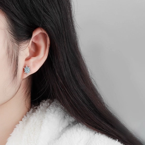 Orecchini a perno a forma di tartaruga in argento con opale blu indossati