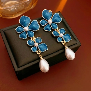 Vintage drop earrings featuring deep blue enamel flowers and elegant teardrop pearls