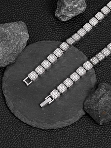 Close-up of 13mm silver tone Cuban link chain with pave rhinestones on dark stone base