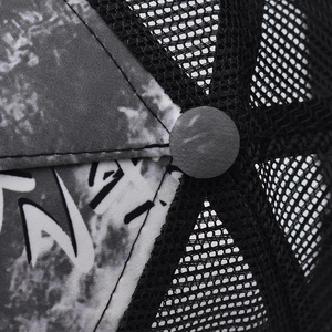 Detail of the breathable black mesh and top squatchee on the gradient trucker hat