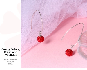 Detail of red disco ball earrings featuring sparkling crystals and silver hook wires