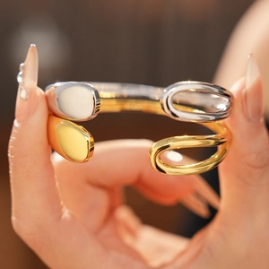 Detailed close-up of gold and silver plated open bangles with high-polish mirror finish