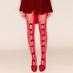 Vue détaillée des leggings en résille rouge avec des nœuds noirs et une texture fine