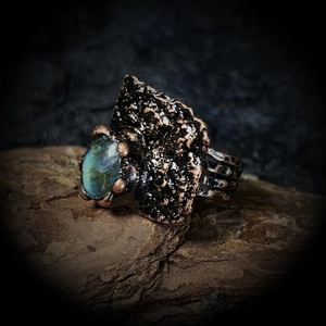 Détail macro d'une bague en bronze vintage avec pierre bleu-vert sur écorce de bois
