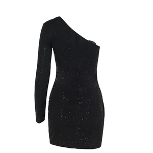Detalle de lentejuelas plateadas brillantes en la tela de un vestido negro de un hombro