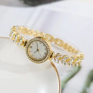 Elegant gold mermaid style watch for women with rhinestones on a ceramic tray