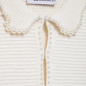 Ensemble élégant en tricot blanc pour femme avec col perlé et texture côtelée chic