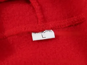 Close-up of red fleece hoodie interior featuring size L label and collar stitching