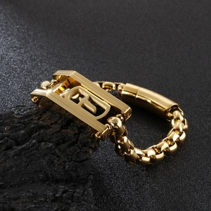 Macro detail of 18K gold plated hip-hop chain bracelet on textured black rock