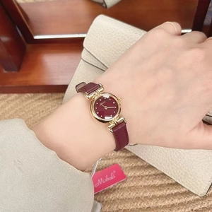 Detail of elegant gold case and burgundy leather strap of this luxury women's watch