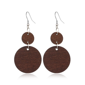 Detailed close-up of vintage brown wood hollow round drop earrings with silver hooks