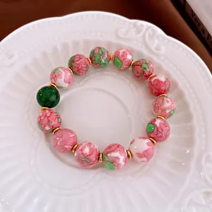 Pink and green beaded ceramic bracelet with gold-plated spacers in a vintage style