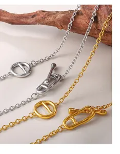 Close-up of gold and silver stainless steel OT buckle necklaces with hammered texture