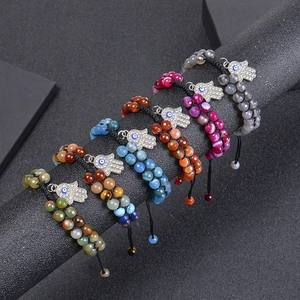 Vintage Hamsa Hand and Evil Eye beaded bracelets with natural stones on a display stand
