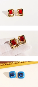Detail view of retro red enamel earrings with large zircon and gold irregular textured frames