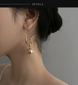 Nahaufnahme eleganter goldener Perlenohrringe im französischen Vintage-Stil an einem Model