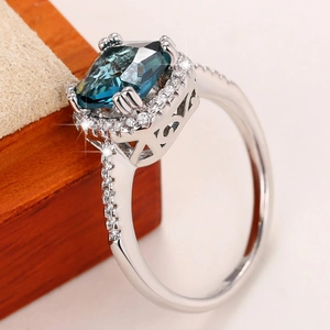 Vintage royal blue cushion cut ring in silver with pavé diamonds on a wood box